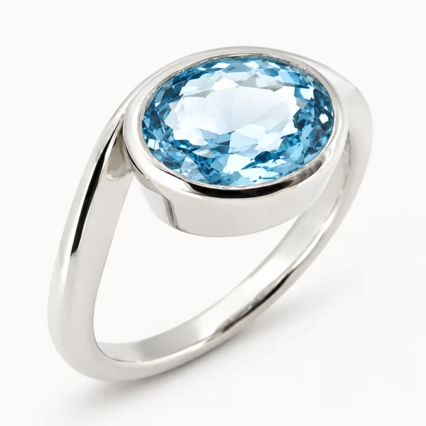 Anillo de oro blanco con topacio azul natural talla oval